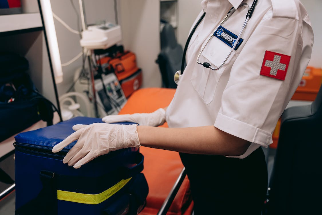 EMS professional preparing an emergency medical kit inside an ambulance for patient care and treatment