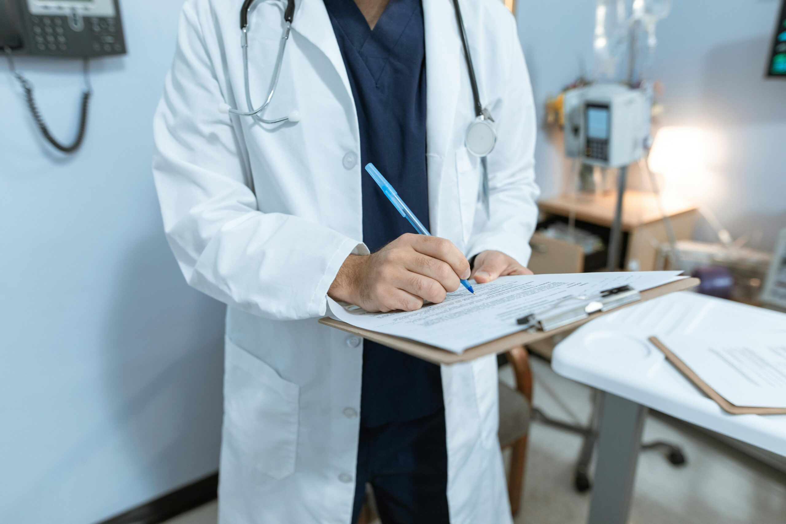 Doctor holding a clipboard and pen, reviewing patient information and preparing for consultation