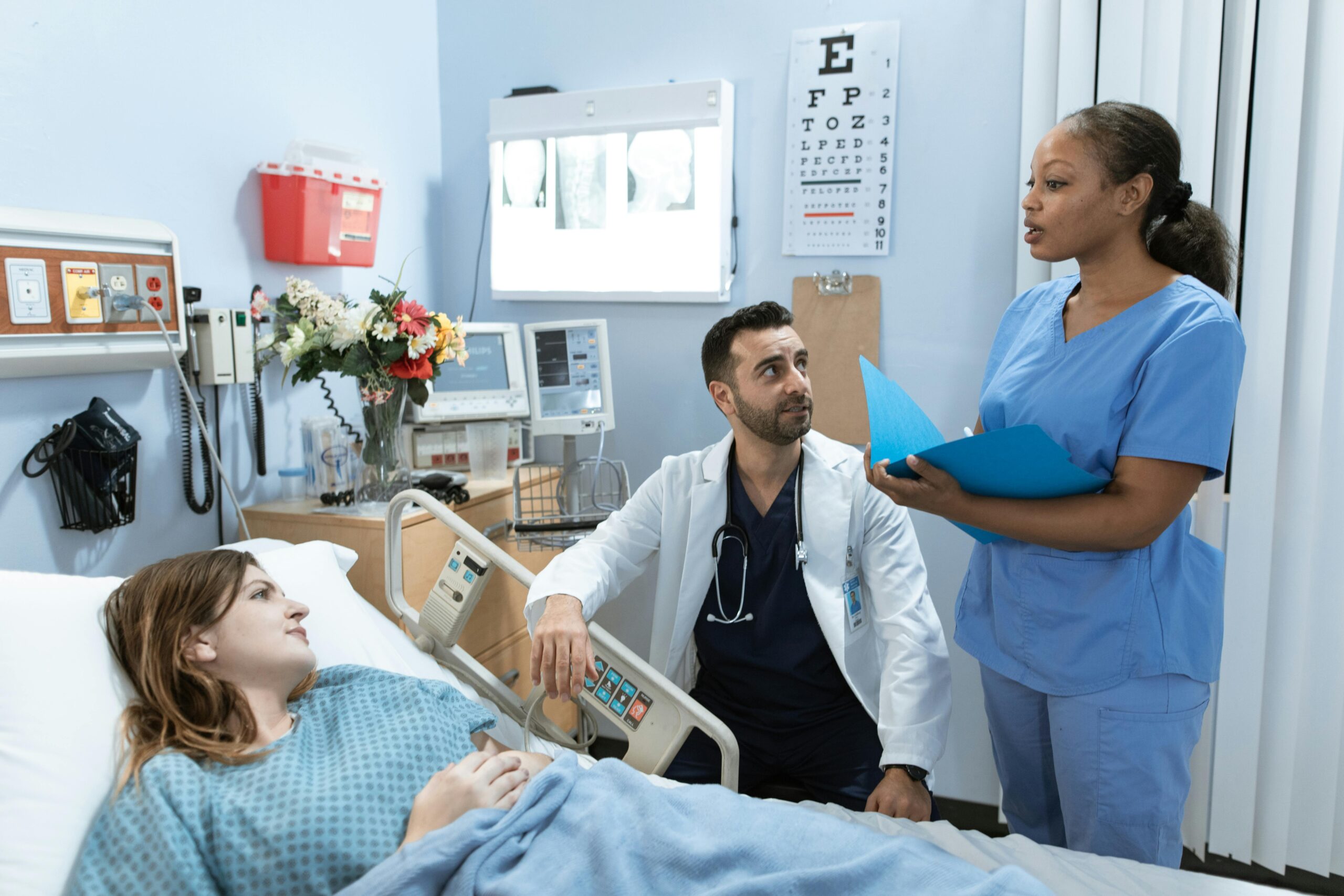 Hospital room with a doctor and nurse attending to a patient, providing medical care and support