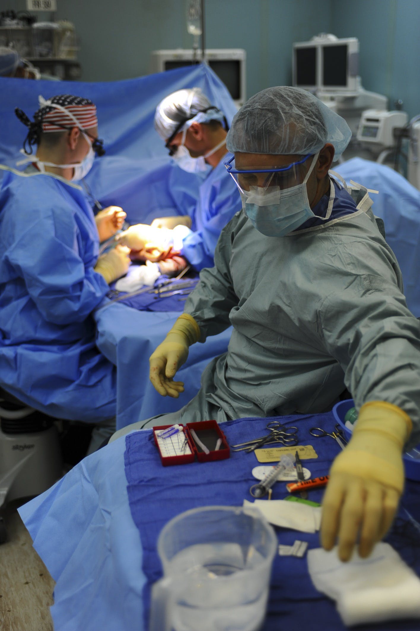 Emergency room with surgeons performing a surgery, surrounded by medical equipment and staff