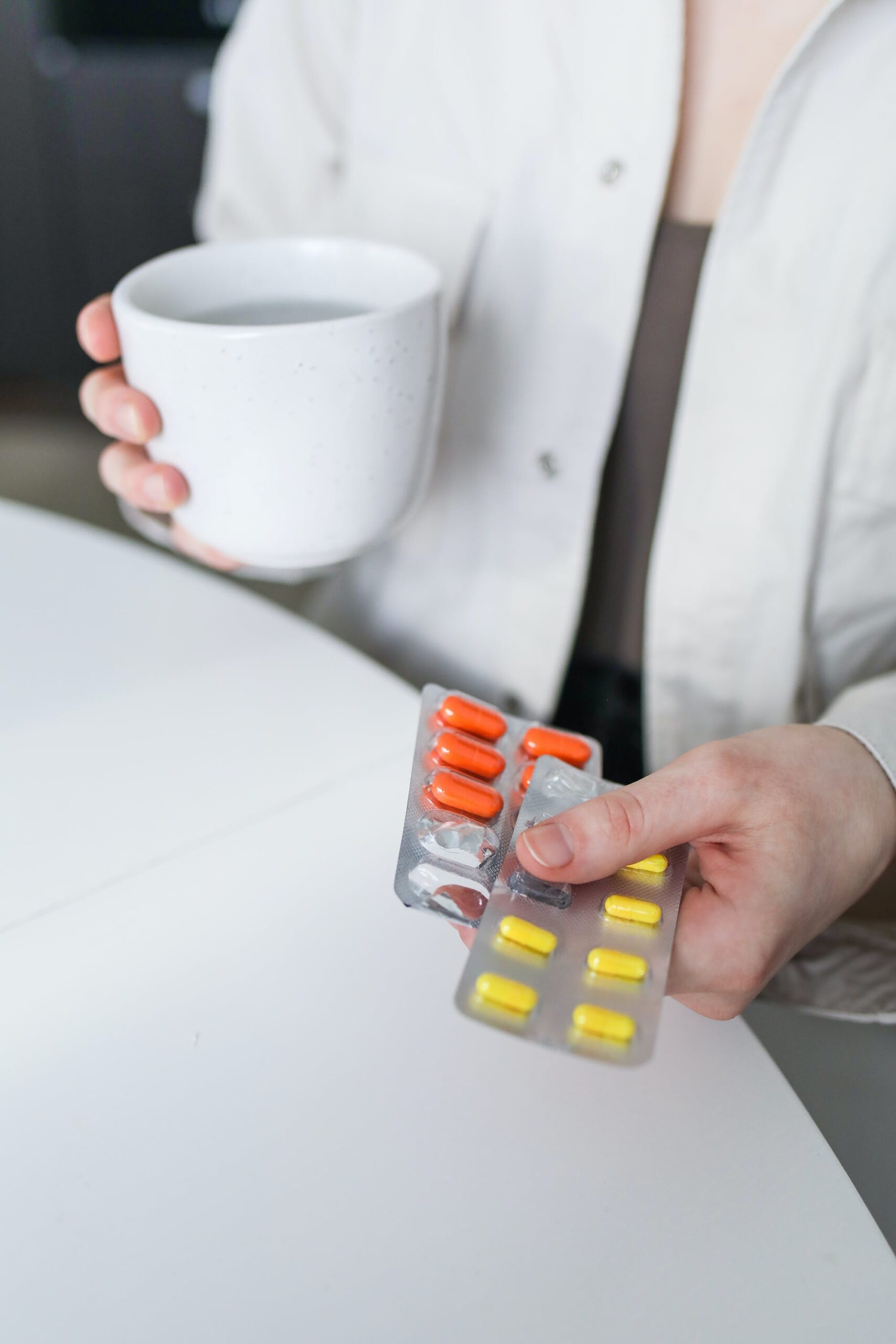 Person holding a blister pack of medication with individual pills clearly visible