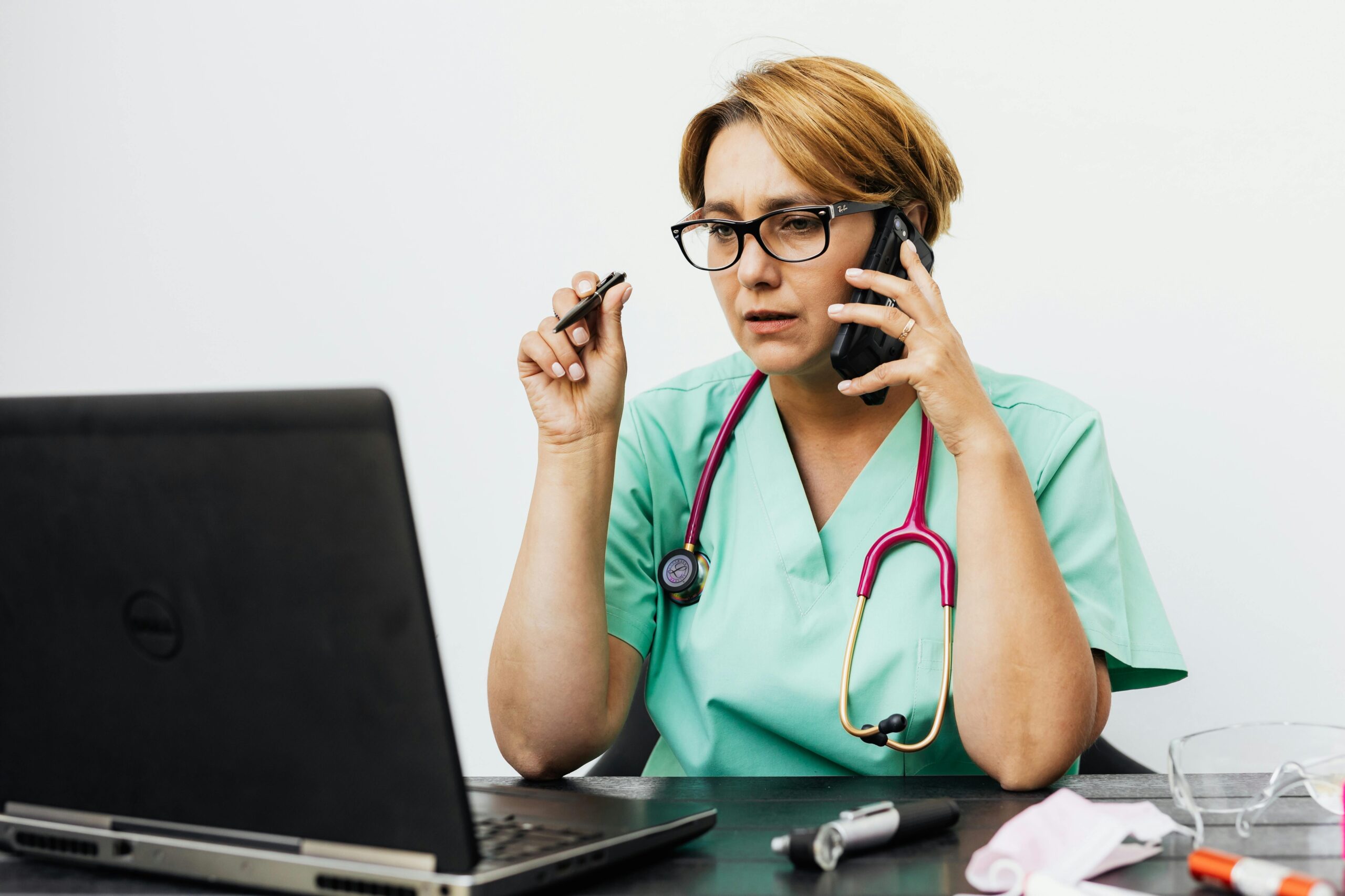 Nurse talking on the phone with a patient, providing medical advice and support