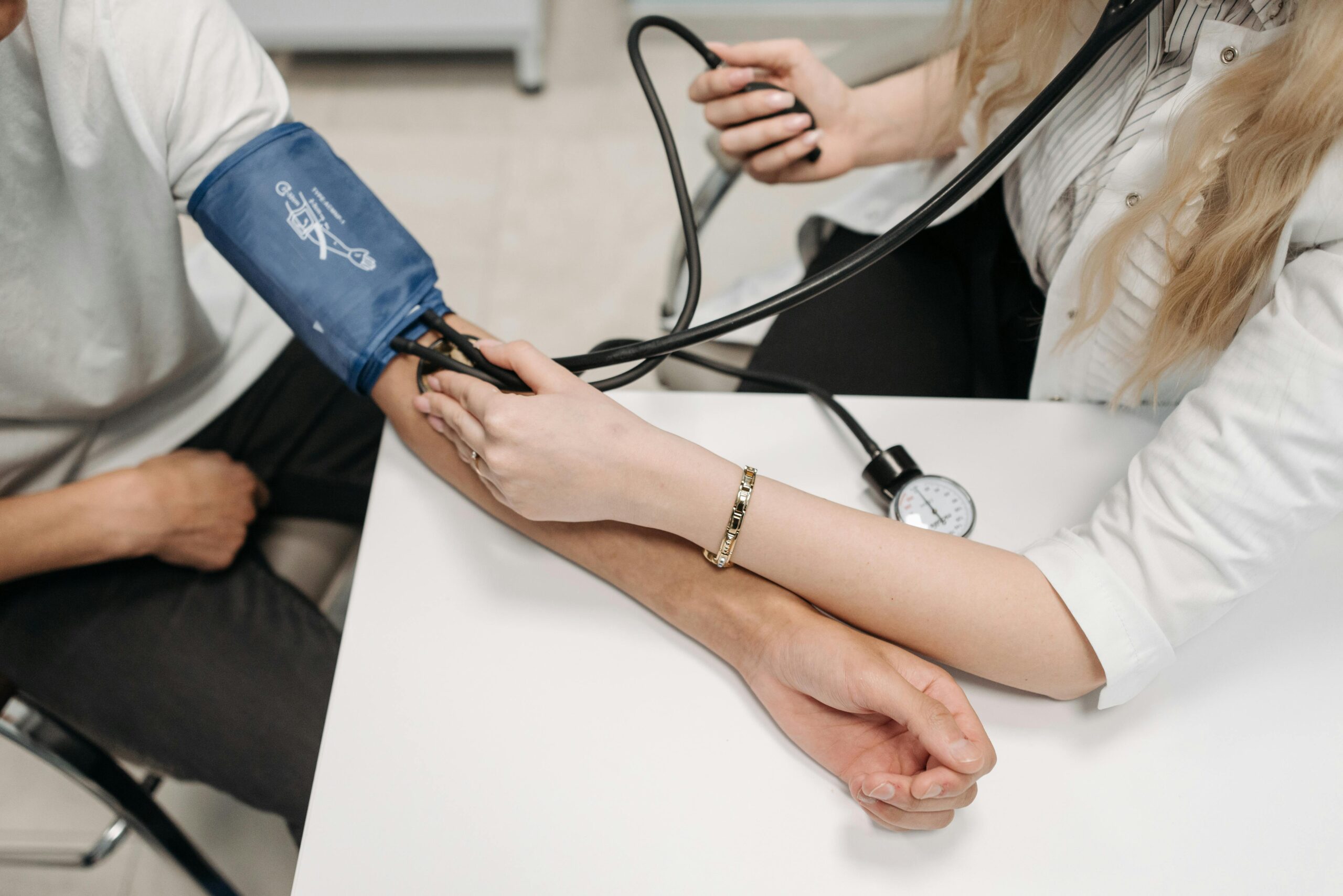 Doctor measuring a patient's blood pressure using a sphygmomanometer in a medical setting