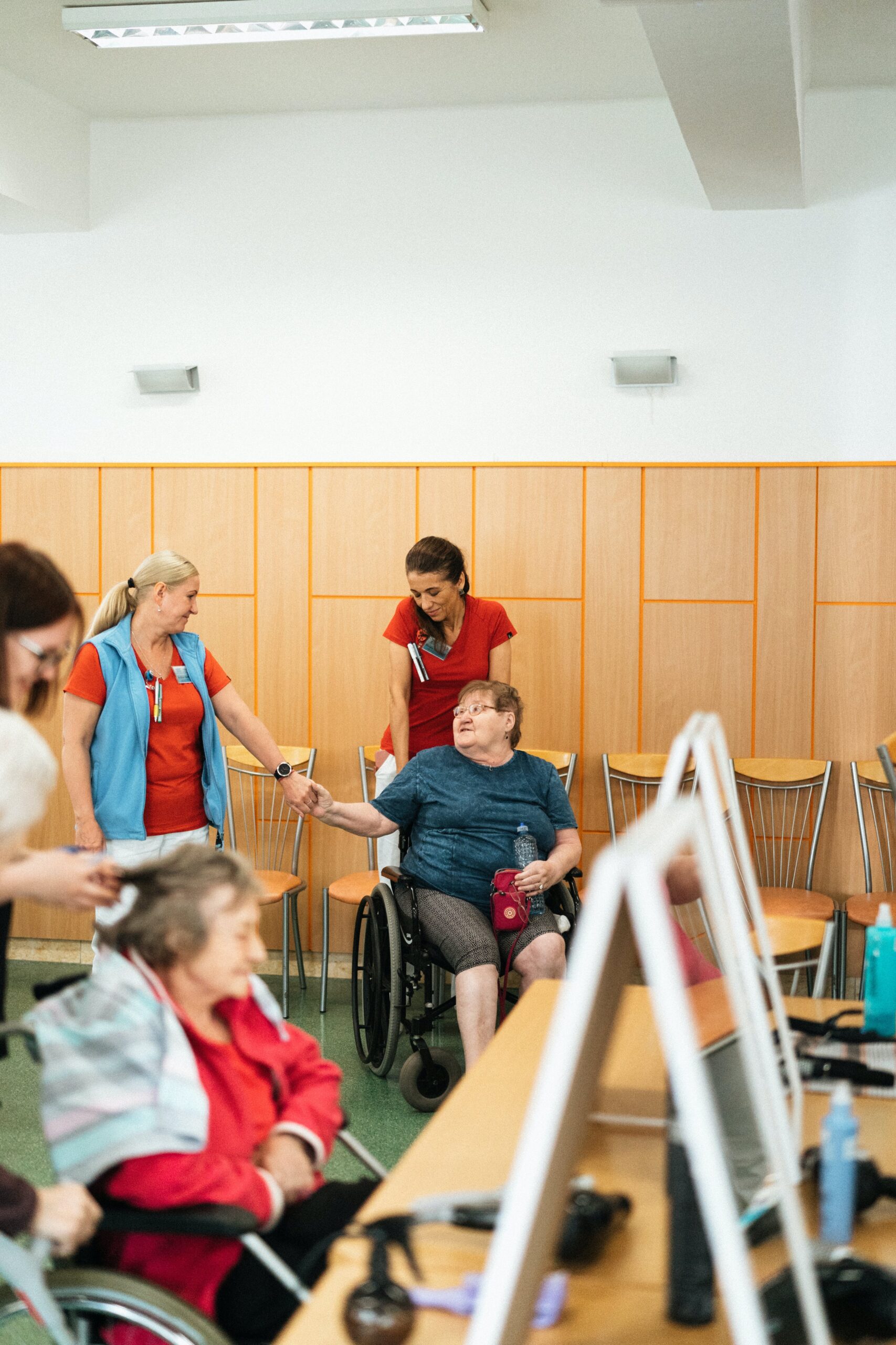 Long-term care center with elderly residents receiving care and assistance from nurses in a comfortable setting