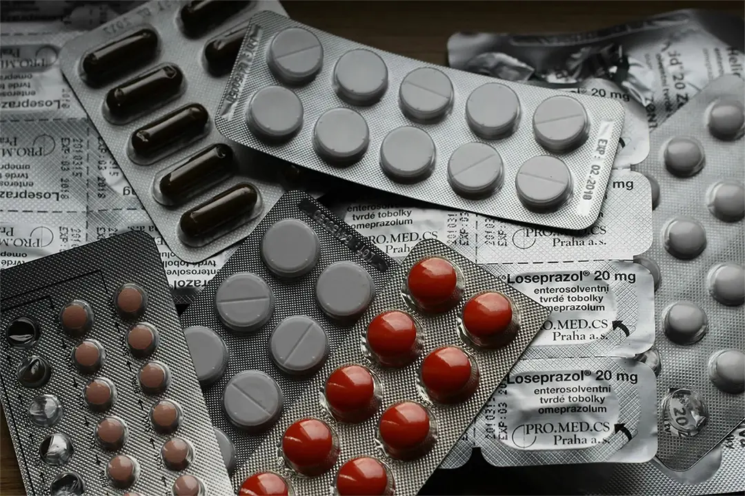Scattered medications on a surface, showcasing various prescriptions and over-the-counter drugs