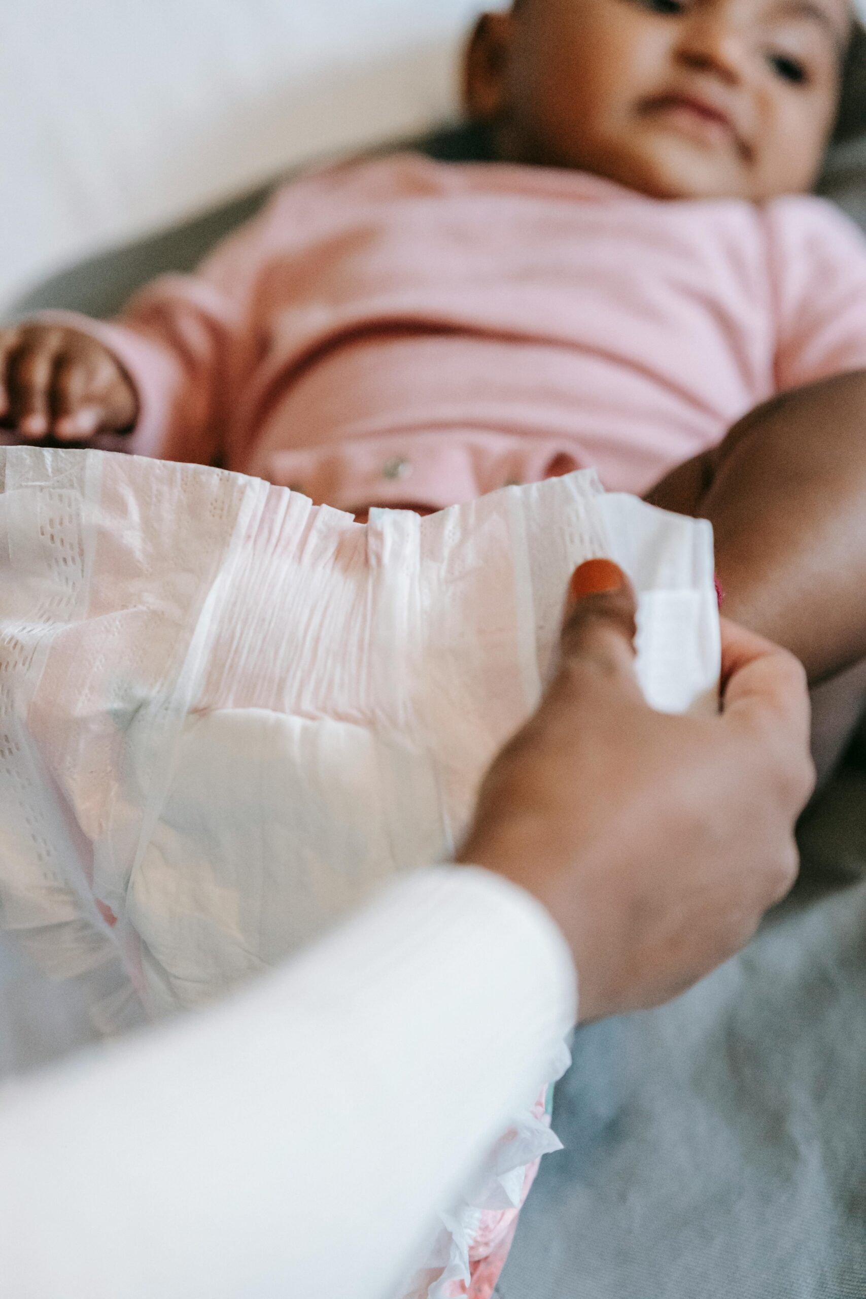 Baby lying on a changing station with a focus on a clean, soft diaper