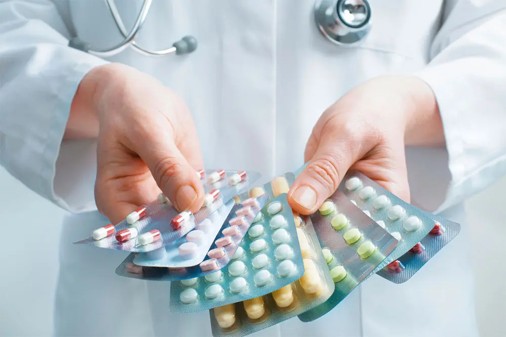 Hand of doctors holding many different pills